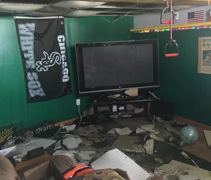 Green room with Chicago White SOX flag and large flat screen TV with water damage